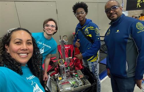 robotics coaches posing with robot